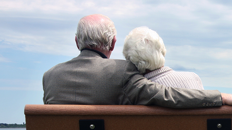 Ouder echtpaar samen op een houten bankje