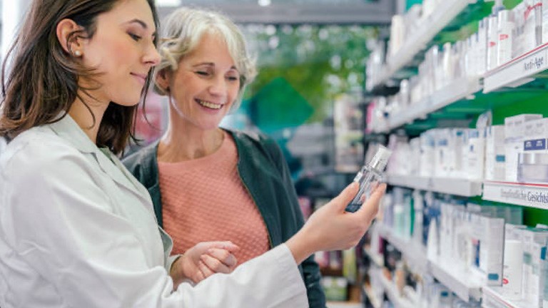 Vrouw krijgt uitleg van apotheker over medicijn