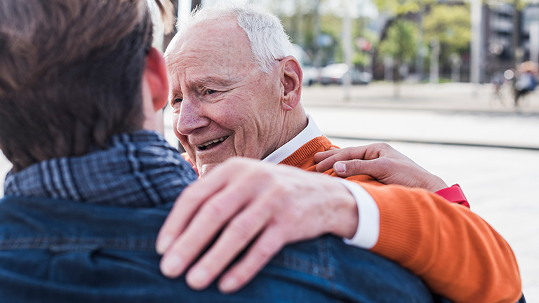 Oude man legt hand op schouder jonge man