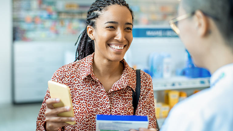 Vrouw haalt medicijnen bij apotheek