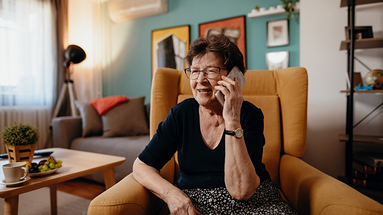 Vrouw op de bank belt met mobiele telefoon