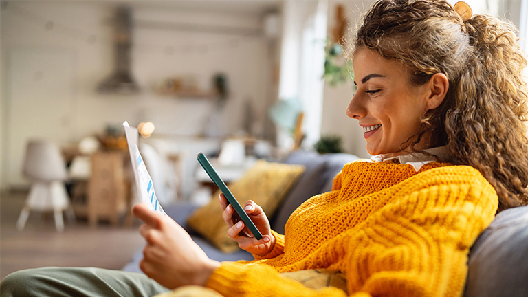 Vrouw met foto van rekening met telefoon