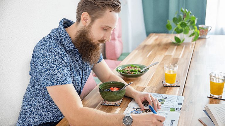 Iemand die krantje leest aan tafel