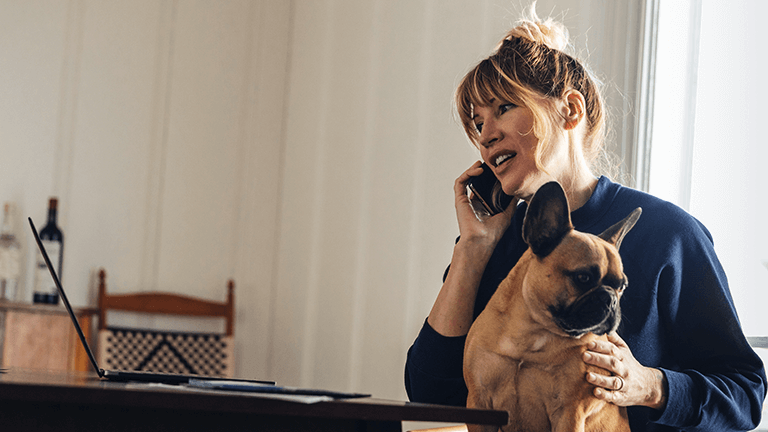 Vrouw belt met hond op schoot
