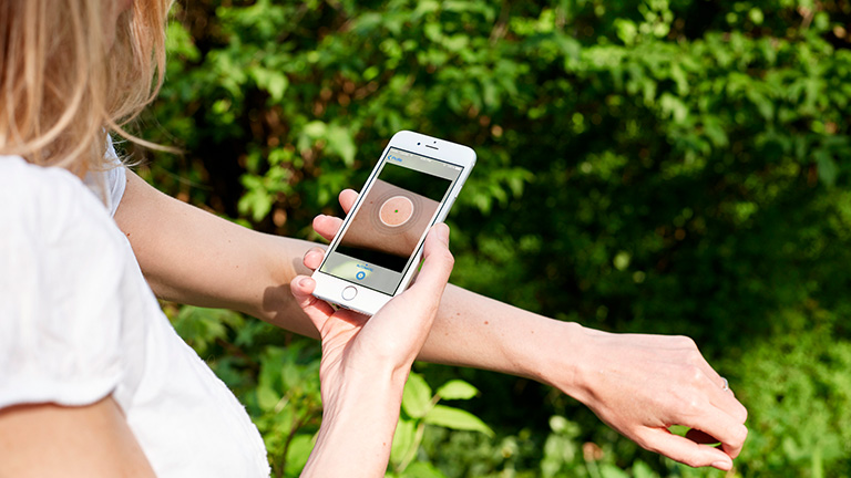 Vrouw scant moedervlek met app