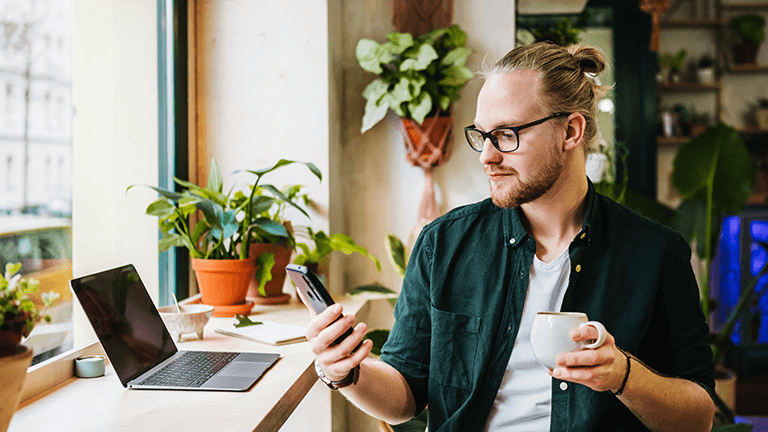 Jongeman kijkt op mobiele telefoon